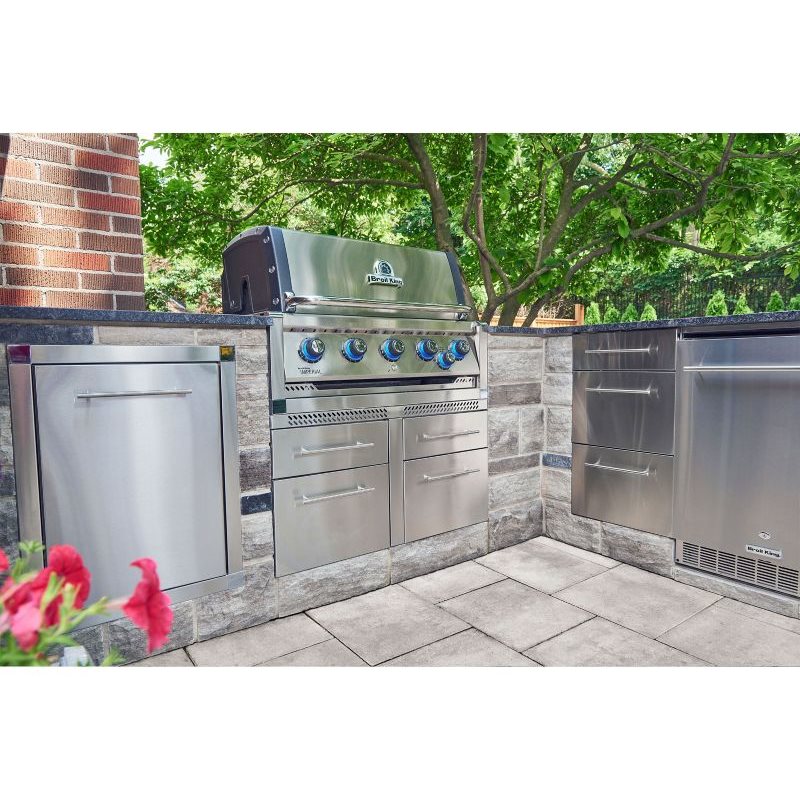 Broil King Imperial built-in grill in outdoor kitchen with illuminated knobs and stainless steel cabinetry.